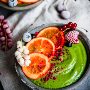 Green smoothie bowl with fruits on it