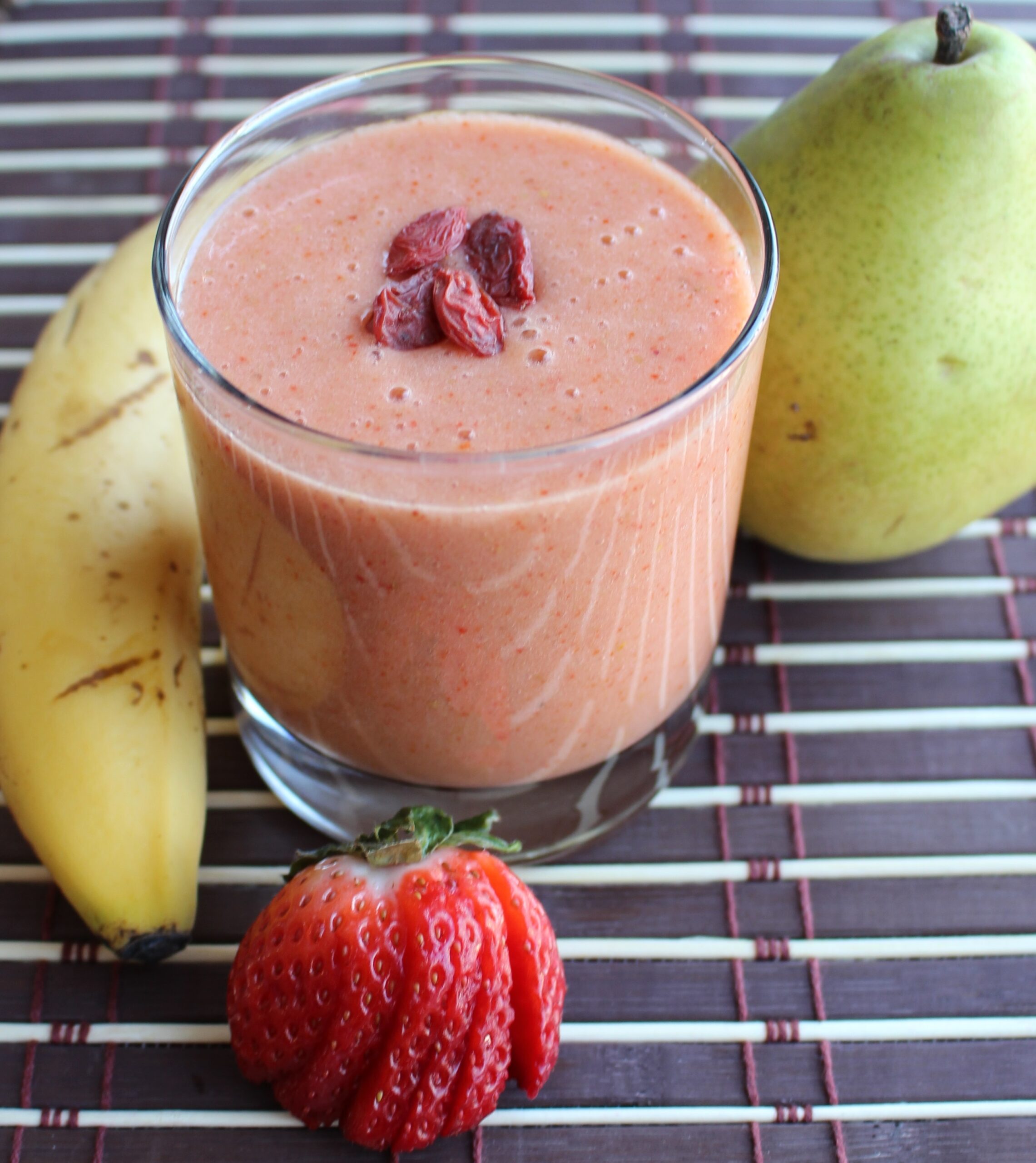 Strawberry smoothie with banana and pear on the side