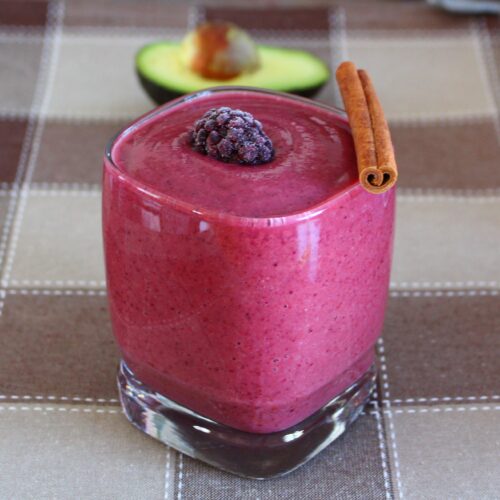 berry smoothie with an avocado in the back