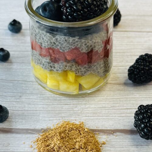 little jar with chia pudding in layers with pineapple chunks, watermelon and berries