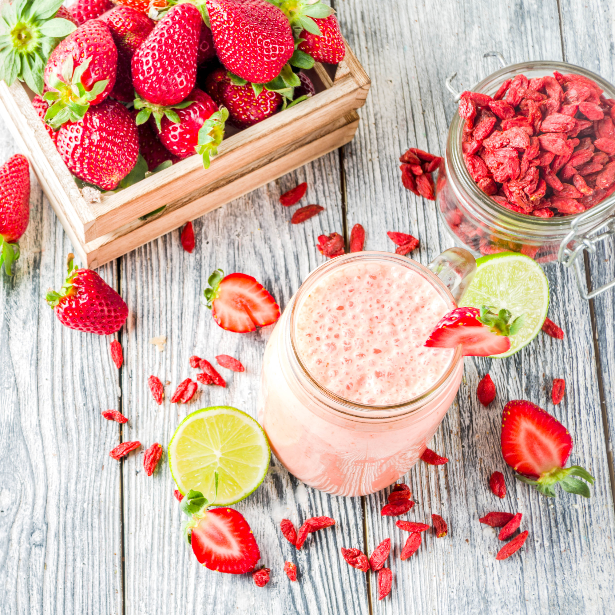Pale smoothie with strawberries around it