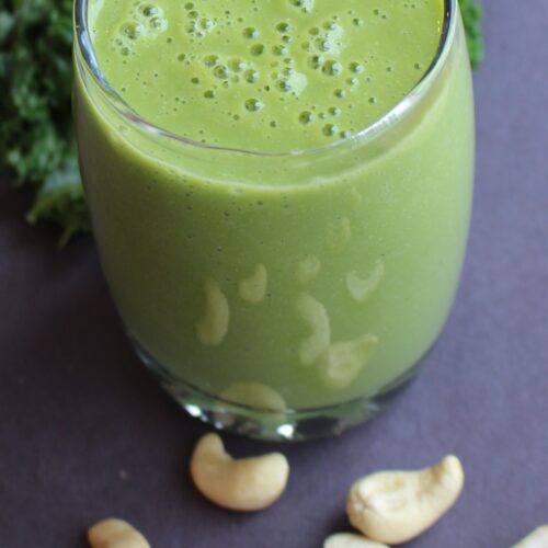 green smoothie with cashew nuts on the side
