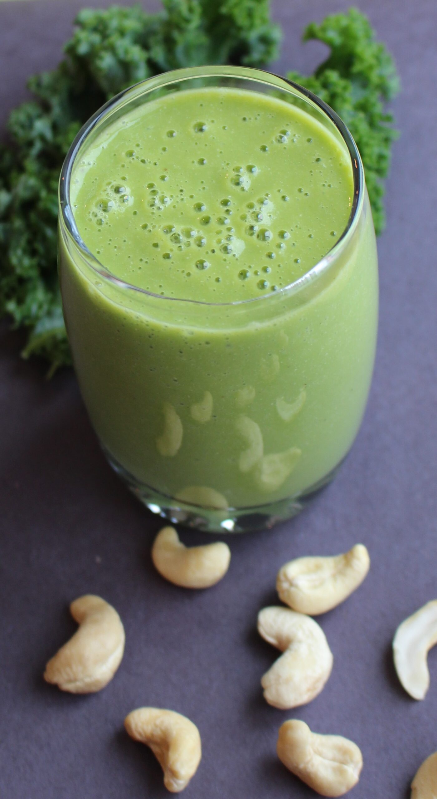 green smoothie with cashew nuts on the side