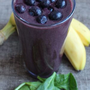 Blueberry smoothie with banana and spinach on the side