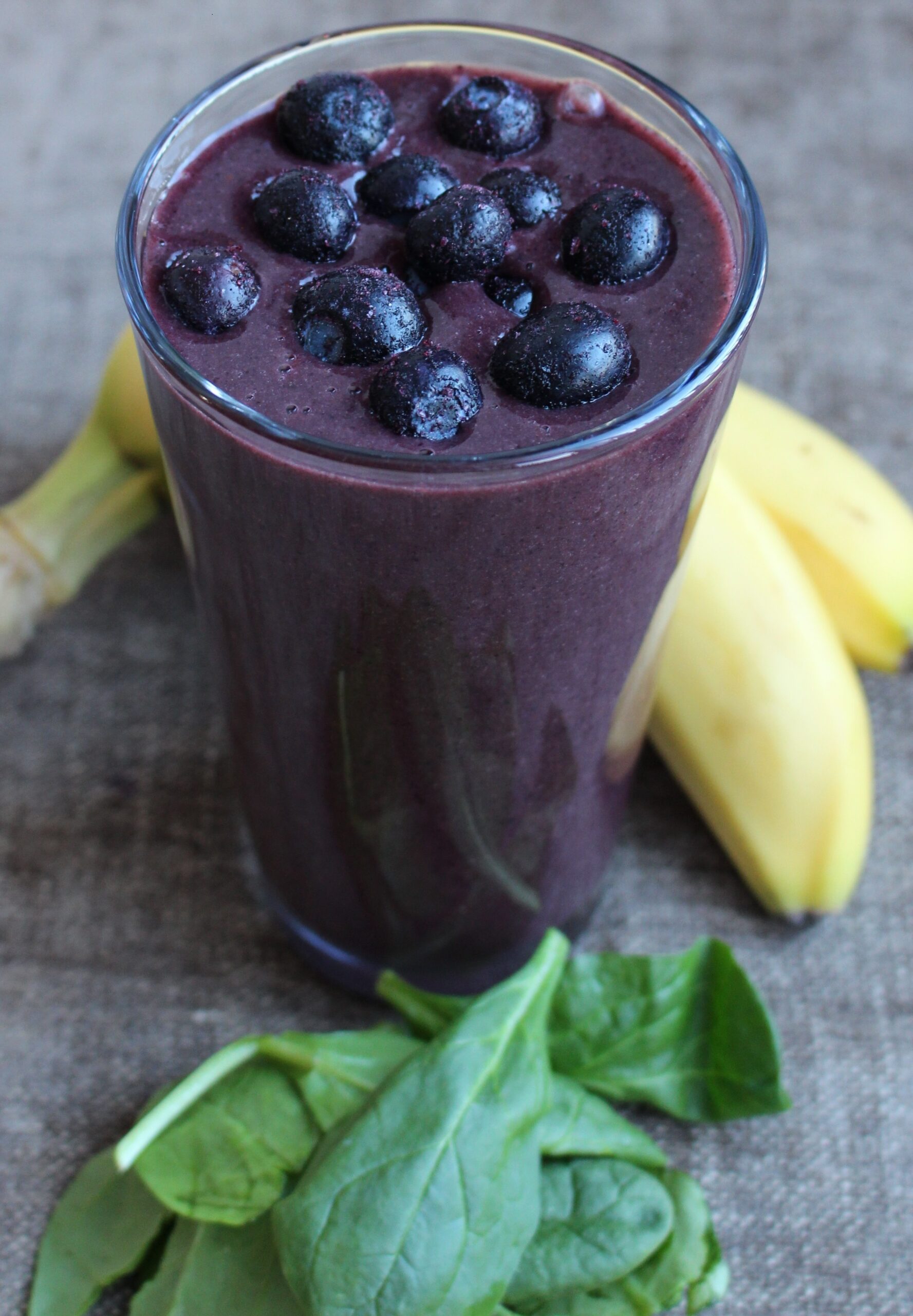 Blueberry smoothie with banana and spinach on the side