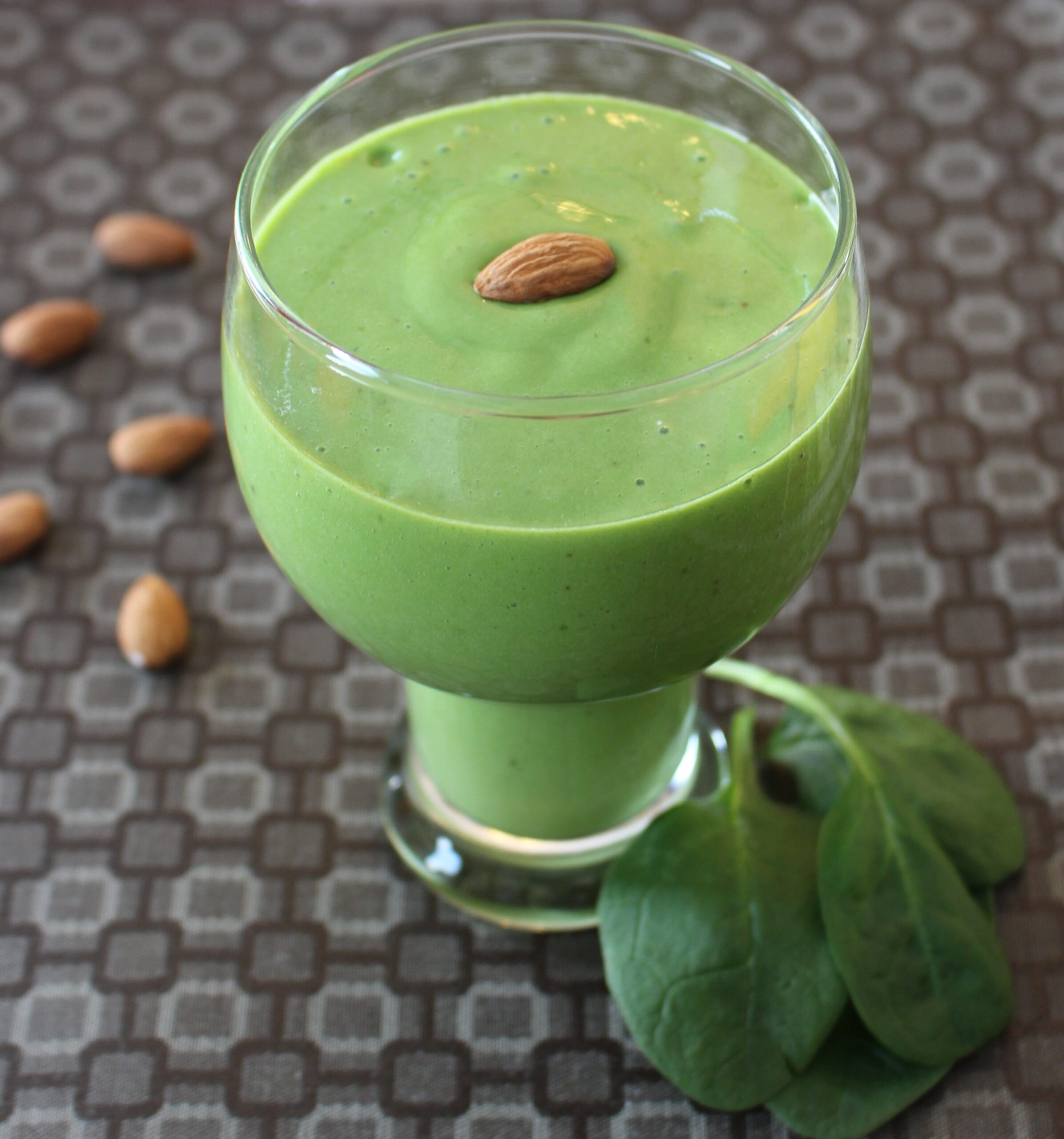 green smoothie with spinach and almonds on the side