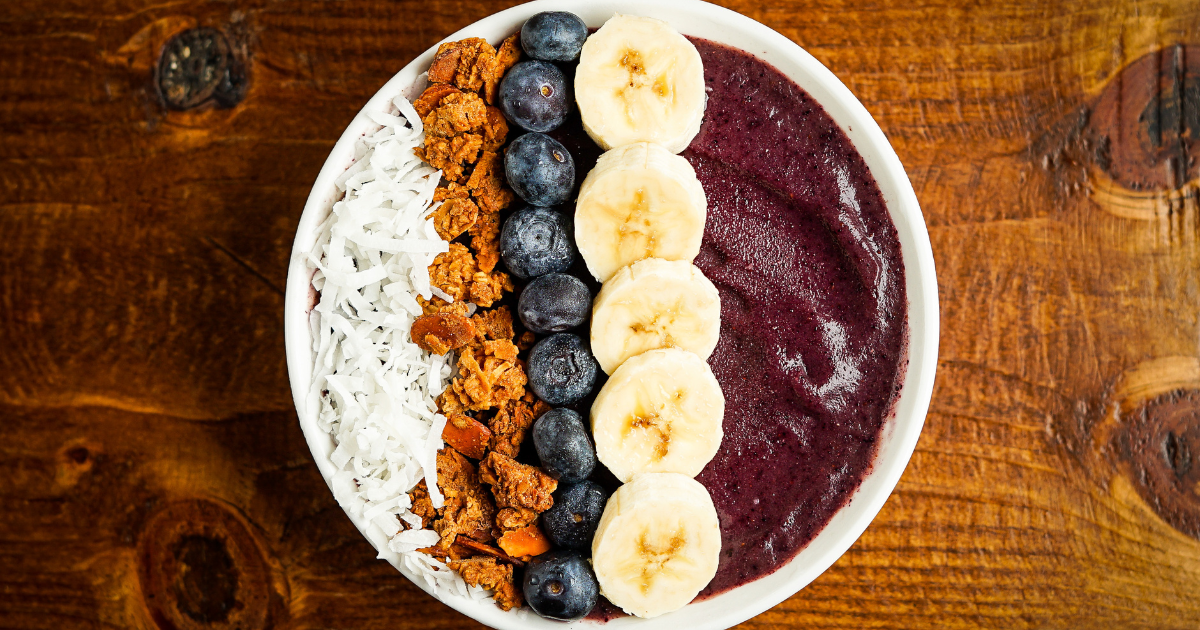 blueberry smoothie bowl with banana slices and granola