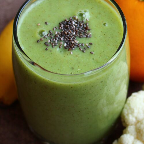kale smoothie with pineapple, banana and orange. chia seeds on top.