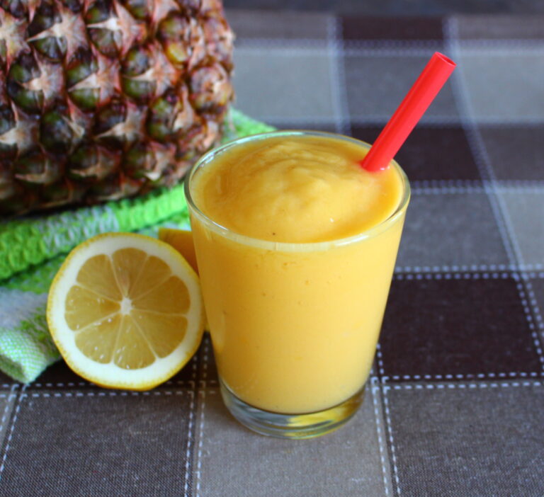 mango smoothie with pineapple and lemon on the side
