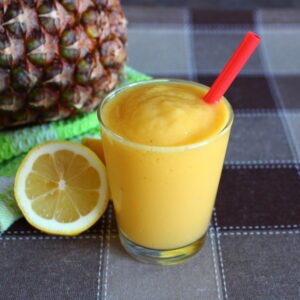 mango smoothie with pineapple and lemon on the side