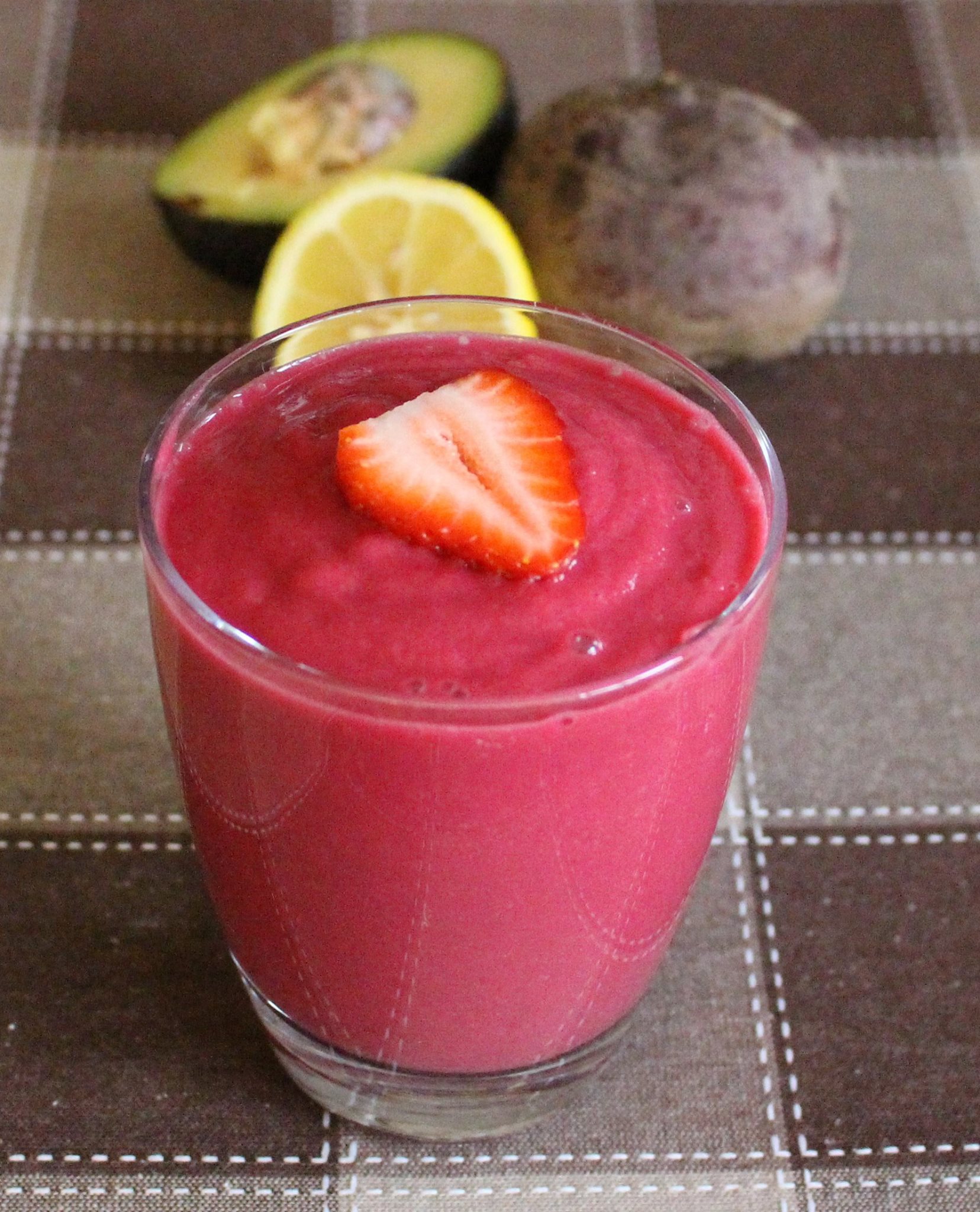strawberry smoothie with lemon and avocado on the side
