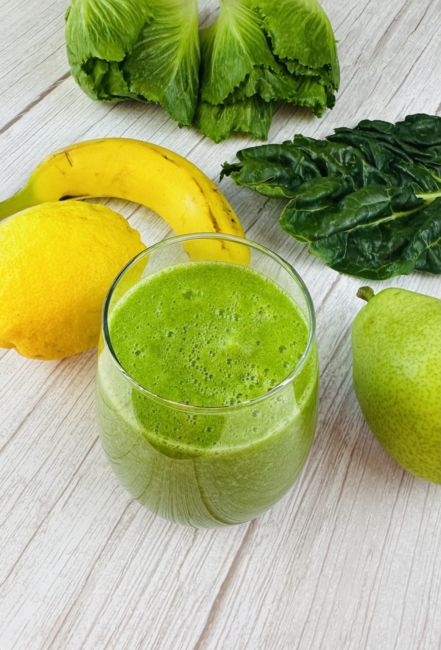 Green smoothie with apple lemon romaine and pear next to it