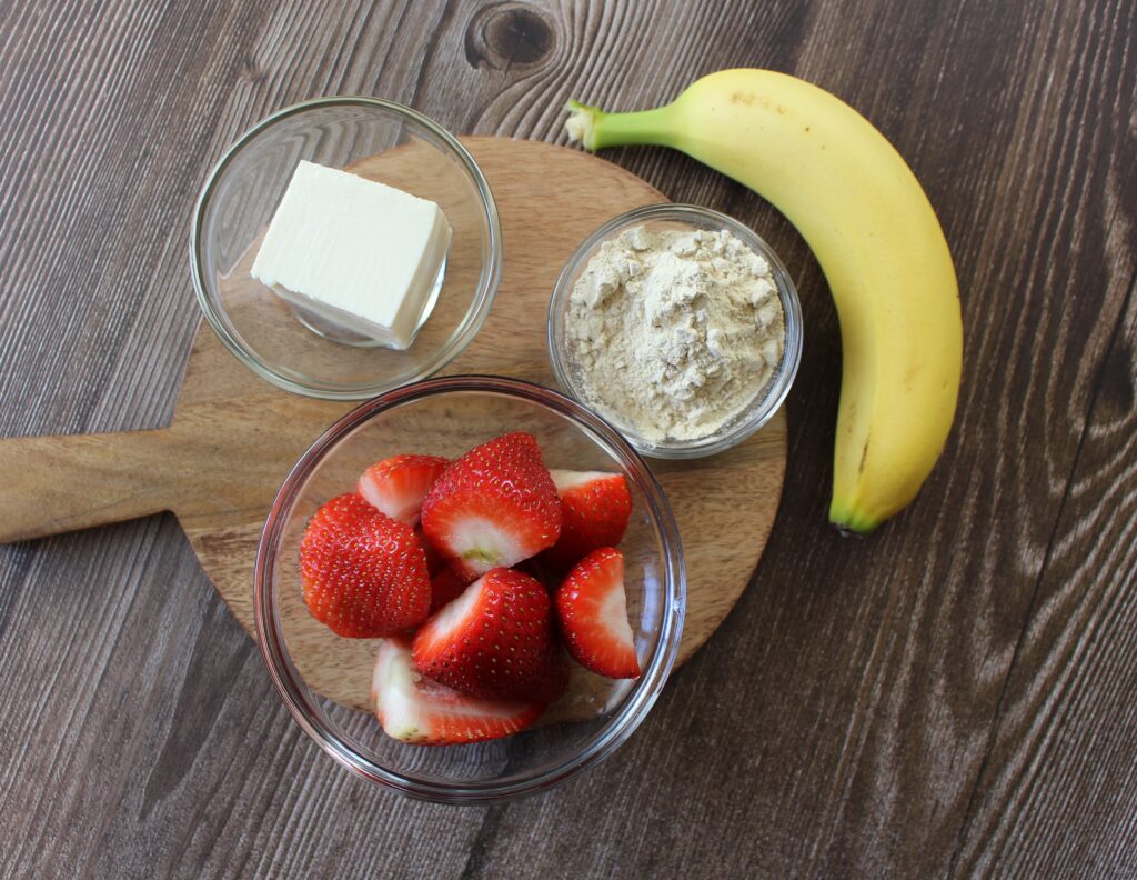 a bowl of strawberries, soft tofu, vanilla protein powder and a banana
