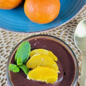 Nice jar of chocolate pudding/mousse with slices of mandarin oranges and mint with some mandarin oranges in the background