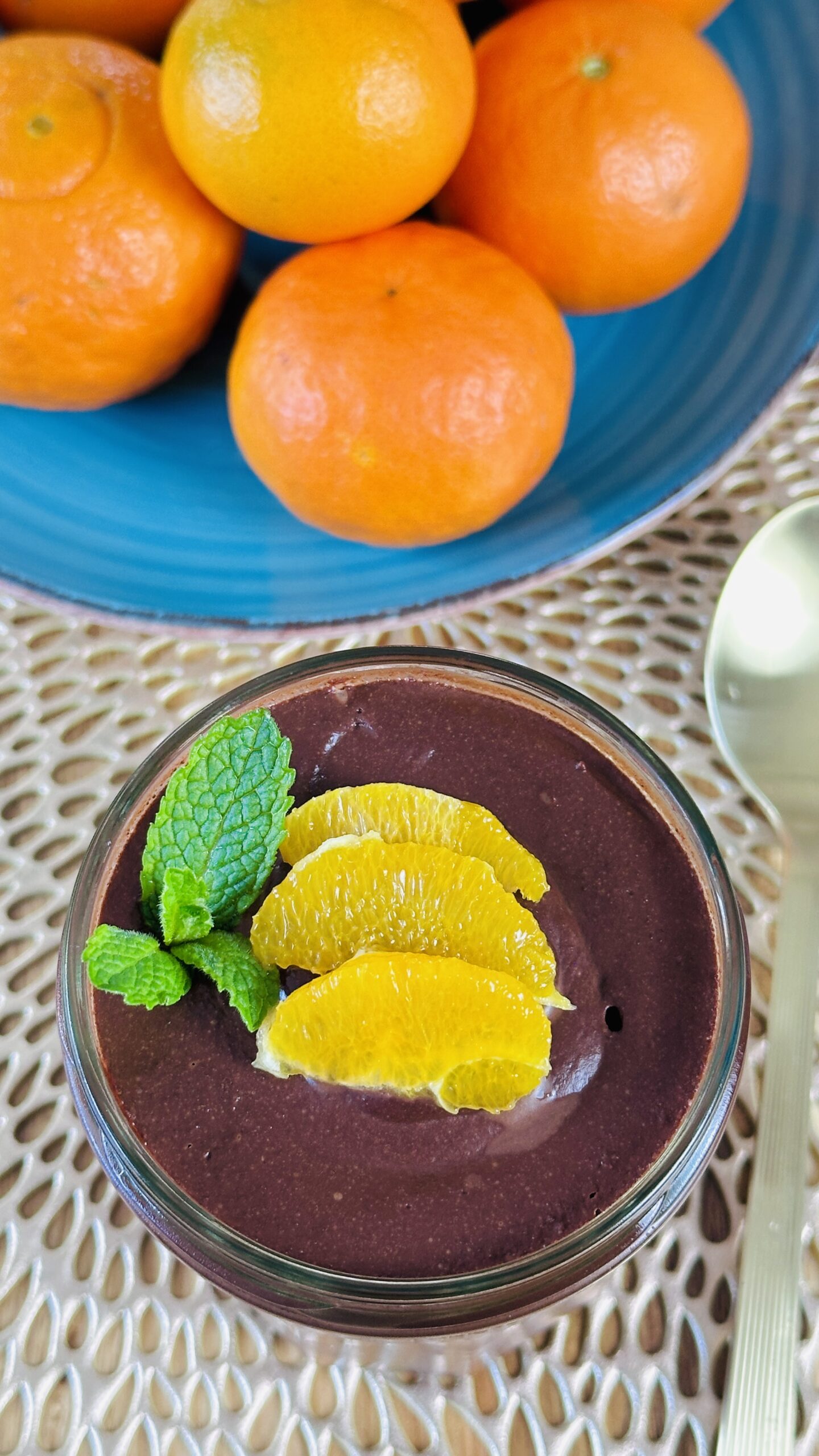 Nice jar of chocolate pudding/mousse with slices of mandarin oranges and mint with some mandarin oranges in the background